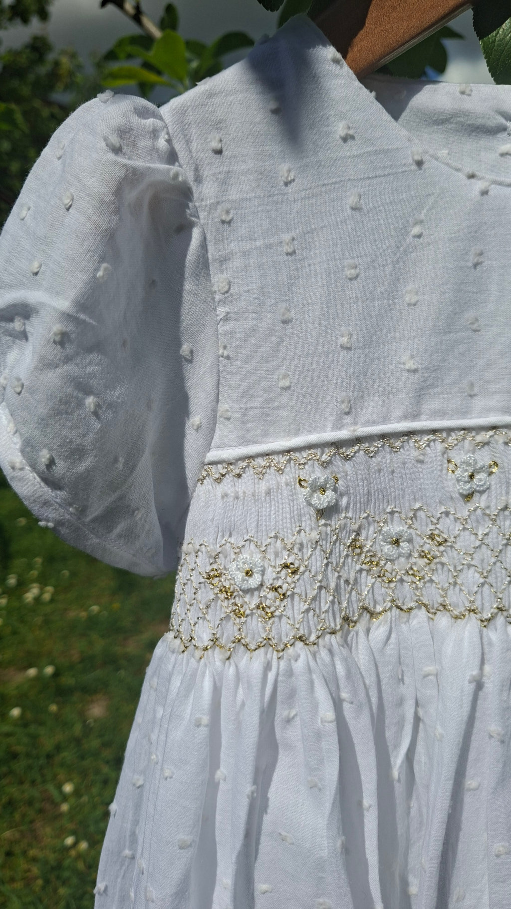 Robe à smocks en plumetis blanc et broderie dorée