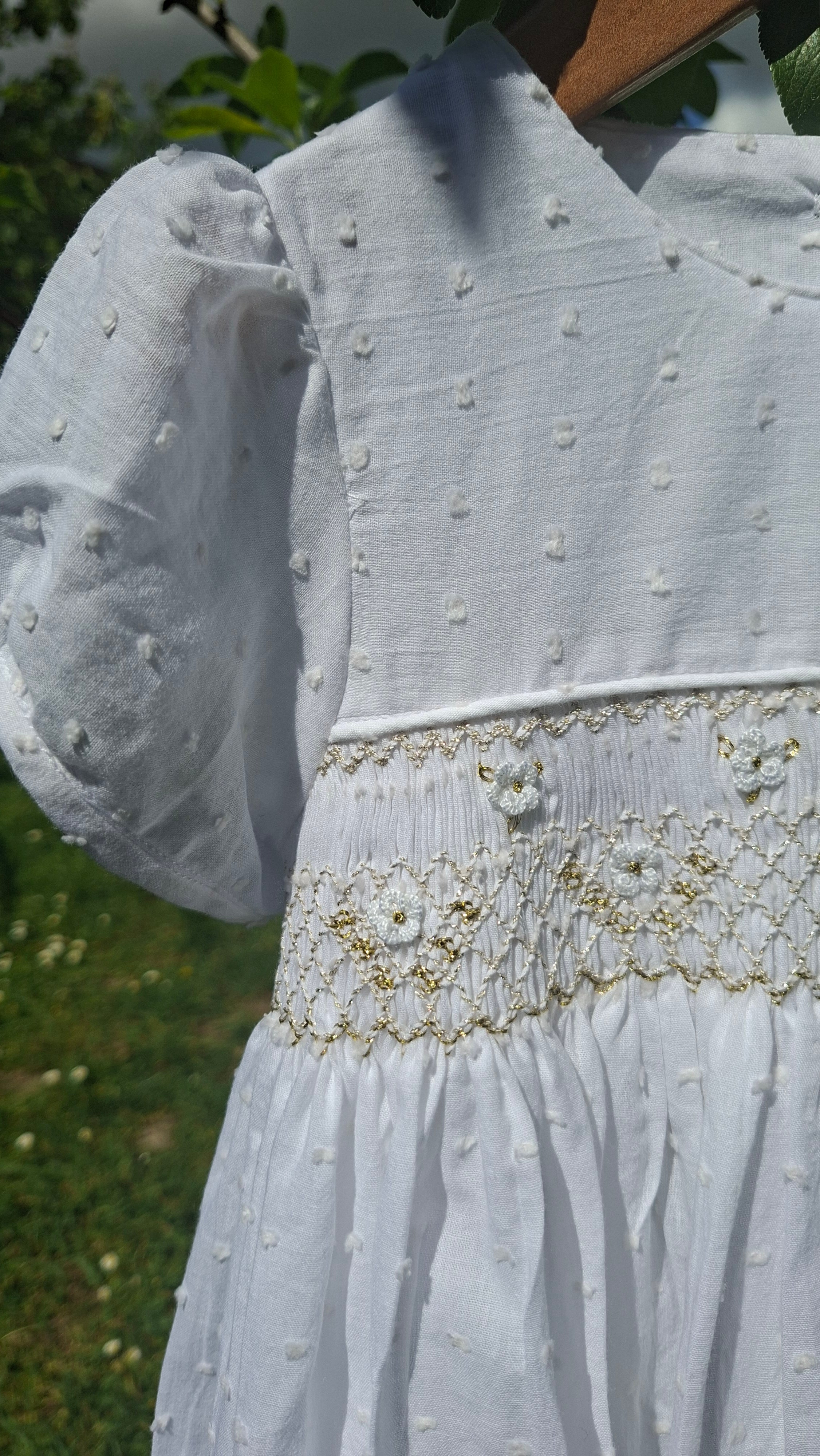 Robe à smocks en plumetis blanc et broderie dorée