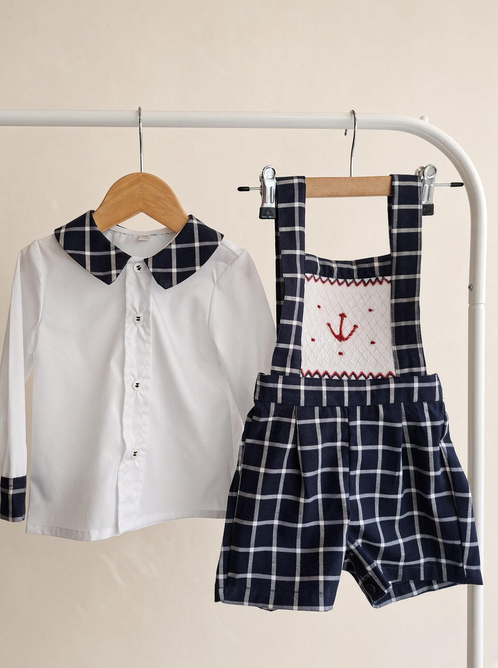 Chemise garçon blanche à col et poignets à carreaux marine.