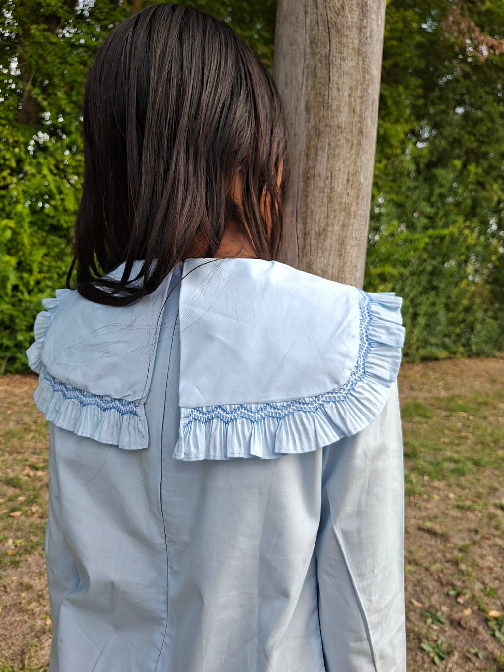en PRE-COMMANDE. Robe bleu clair avec plastron smockée.